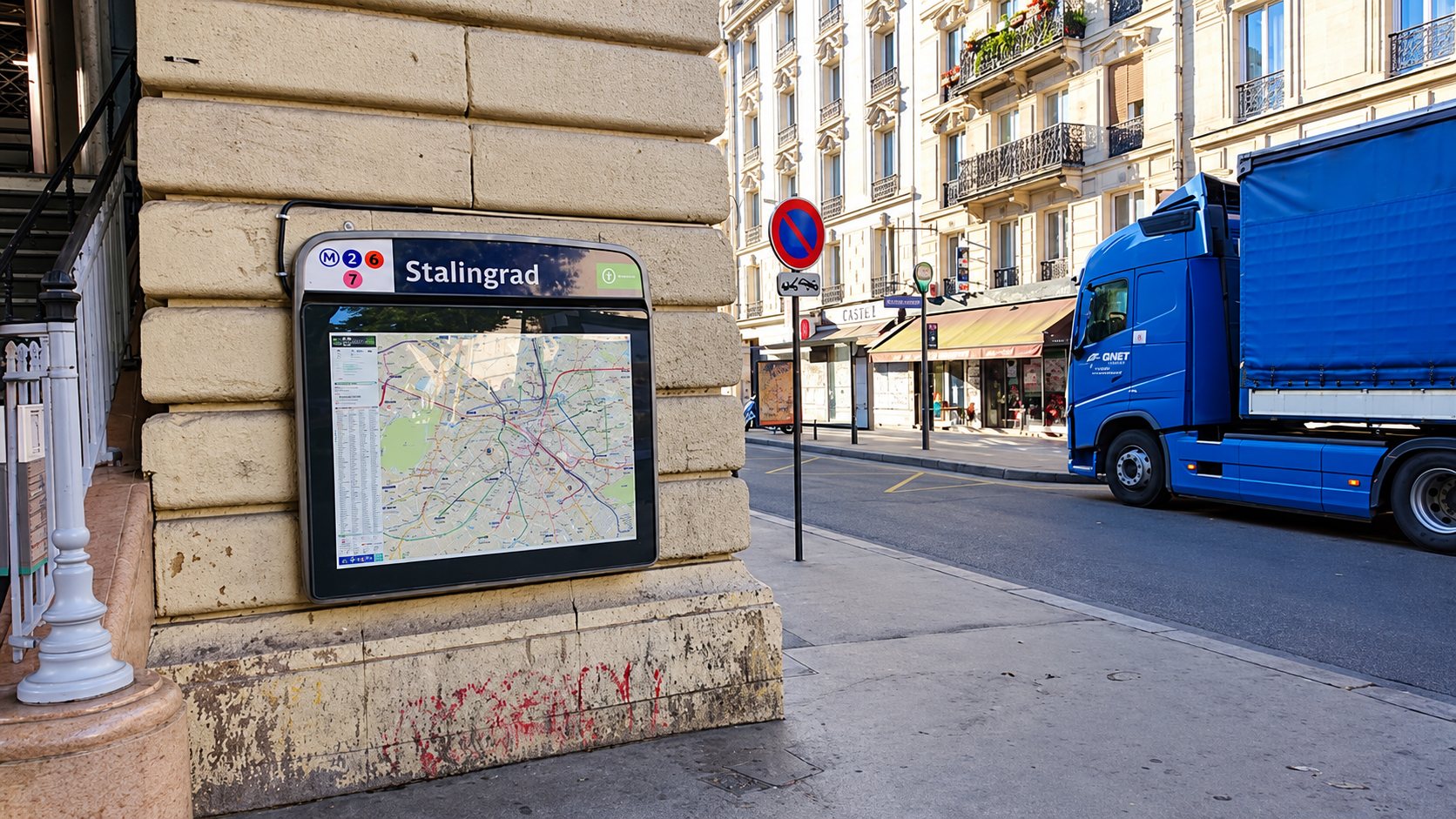 Un camion bleu Gunst dans une rue de Paris, à côté d’un plan de quartier du métro Stalingrad.